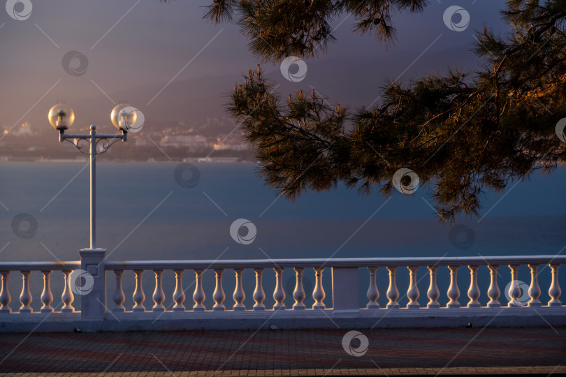 Скачать Курорт Геленджик. Набережная на закате. Балюстрада и набережная в косых лучах заходящего солнца. Кавказские горы на заднем плане. фотосток Ozero
