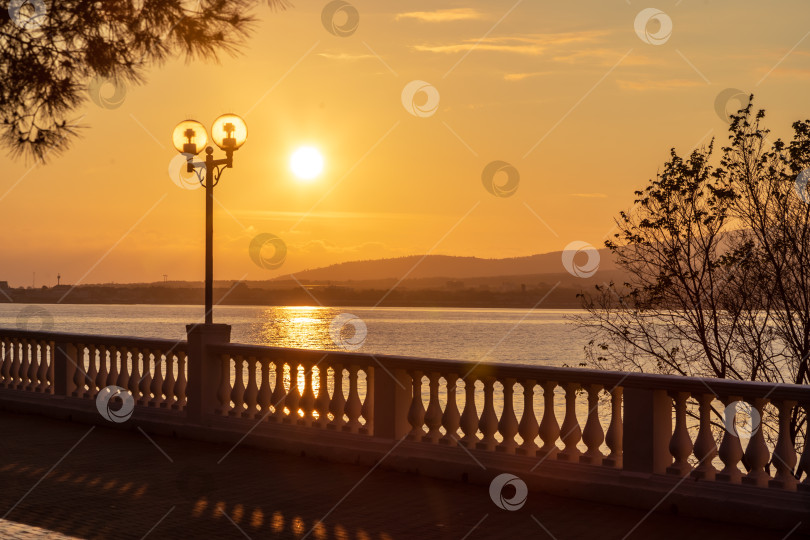 Скачать Курорт Геленджик. Набережная на закате. Балюстрада и набережная в косых лучах заходящего солнца. Кавказские горы на заднем плане. фотосток Ozero