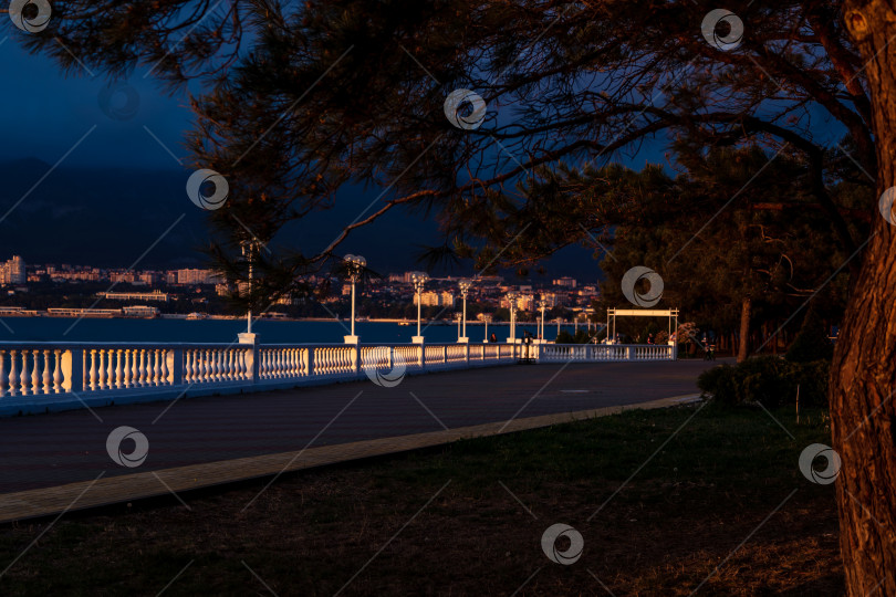 Скачать Курорт Геленджик. Набережная на закате. Балюстрада и набережная в косых лучах заходящего солнца. Кавказские горы на заднем плане. фотосток Ozero