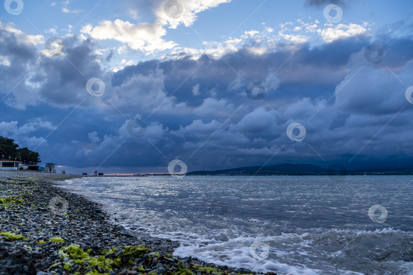 Скачать Пляж Геленджикского курорта на закате. На заднем плане город Геленджик и Кавказские горы в облаках. фотосток Ozero