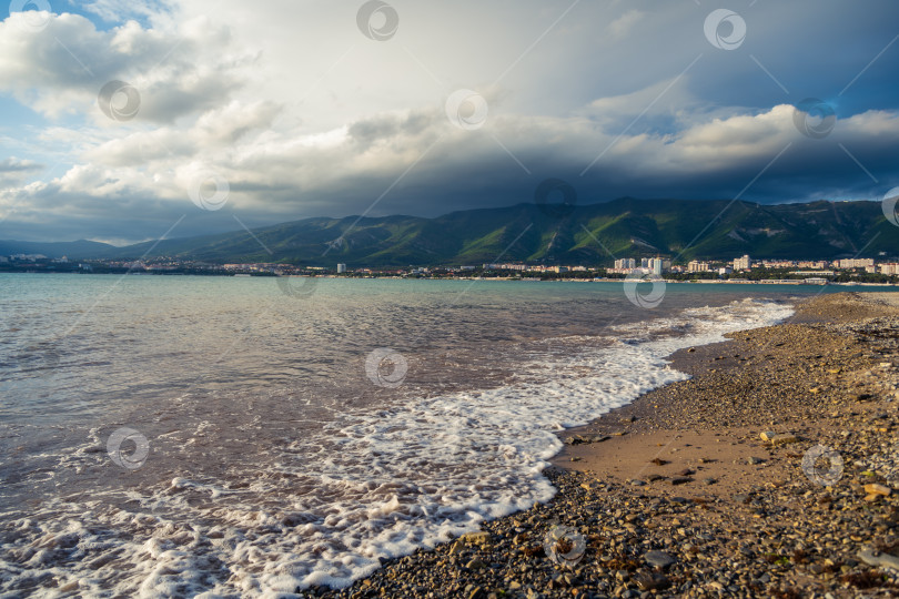 Скачать Пляж Геленджикского курорта на закате. На заднем плане город Геленджик и Кавказские горы в облаках. фотосток Ozero