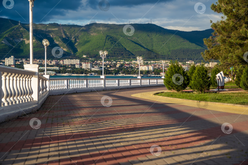 Скачать Город Геленджик. Курортная набережная с балюстрадой и фонарями. Пицундская сосна. На заднем плане Геленджикская бухта и Кавказские горы. фотосток Ozero