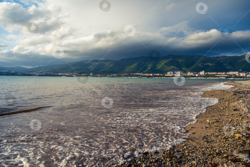 Скачать Пляж Геленджикского курорта на закате. На заднем плане город Геленджик и Кавказские горы в облаках. фотосток Ozero