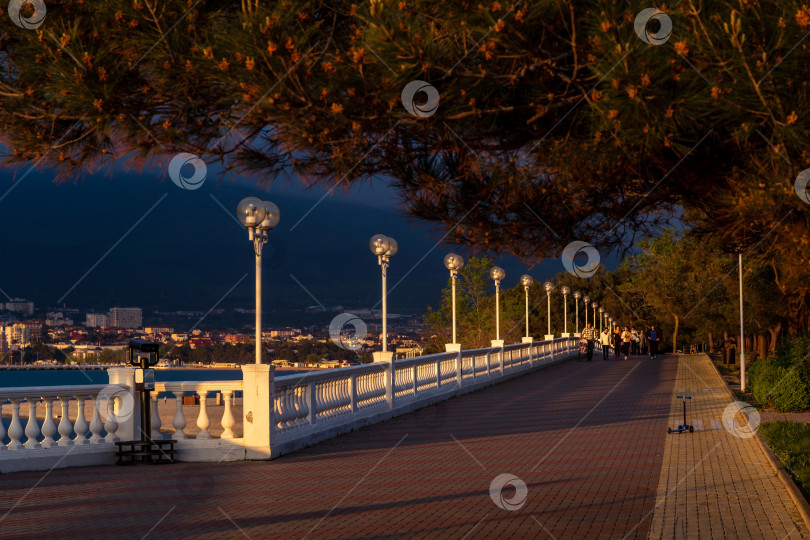 Скачать Курорт Геленджик. Набережная на закате. Балюстрада и набережная в косых лучах заходящего солнца. Кавказские горы на заднем плане. фотосток Ozero