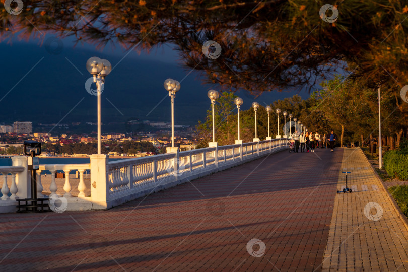 Скачать Курорт Геленджик. Набережная на закате. Балюстрада и набережная в косых лучах заходящего солнца. Кавказские горы на заднем плане. фотосток Ozero