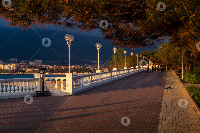 Скачать Курорт Геленджик. Набережная на закате. Балюстрада и набережная в косых лучах заходящего солнца. Кавказские горы на заднем плане. фотосток Ozero