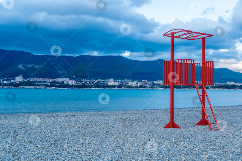 Скачать Курорт Геленджик не в сезон. Зимой спасательная вышка на пляже Геленджикской бухты пустует. На пляже нет людей. Сумерки. фотосток Ozero