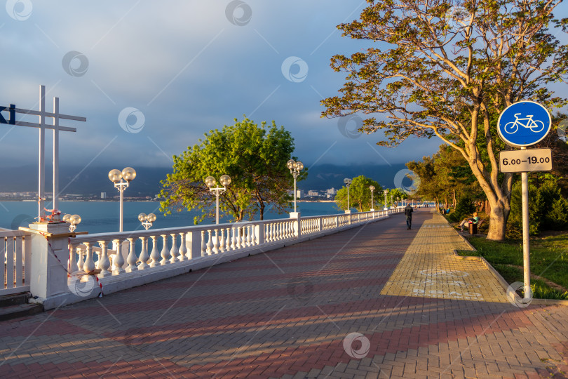Скачать Курорт Геленджик. Набережная на закате. Балюстрада и набережная в косых лучах заходящего солнца. Кавказские горы на заднем плане. фотосток Ozero