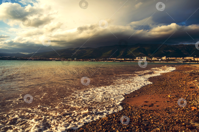 Скачать Пляж Геленджикского курорта на закате. На заднем плане город Геленджик и Кавказские горы в облаках. фотосток Ozero
