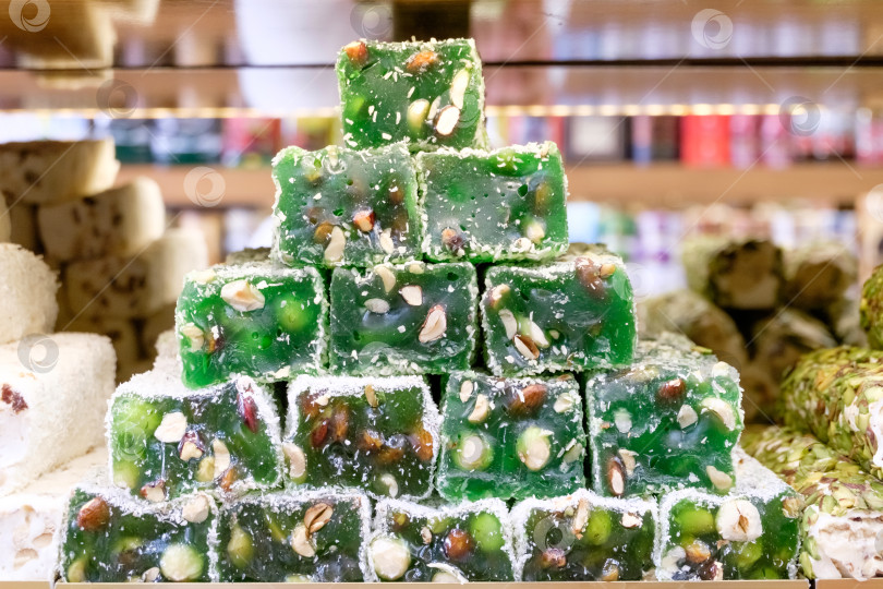 Скачать Стопка зеленых конфет с орехами сверху фотосток Ozero
