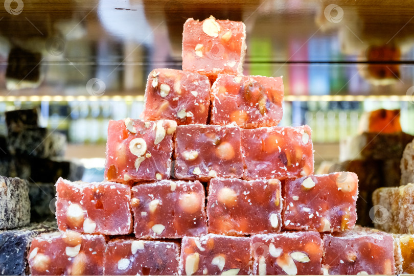 Скачать Стопка красных конфет с орехами сверху фотосток Ozero