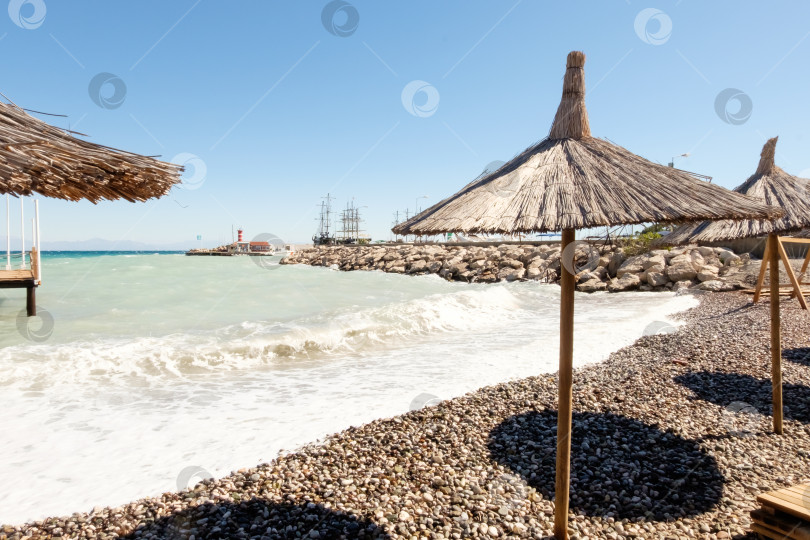 Скачать Пляж с несколькими зонтиками и немногочисленными людьми фотосток Ozero