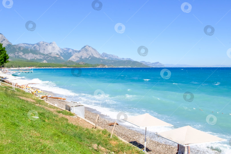 Скачать Пляж с несколькими зонтиками и немногочисленными людьми фотосток Ozero