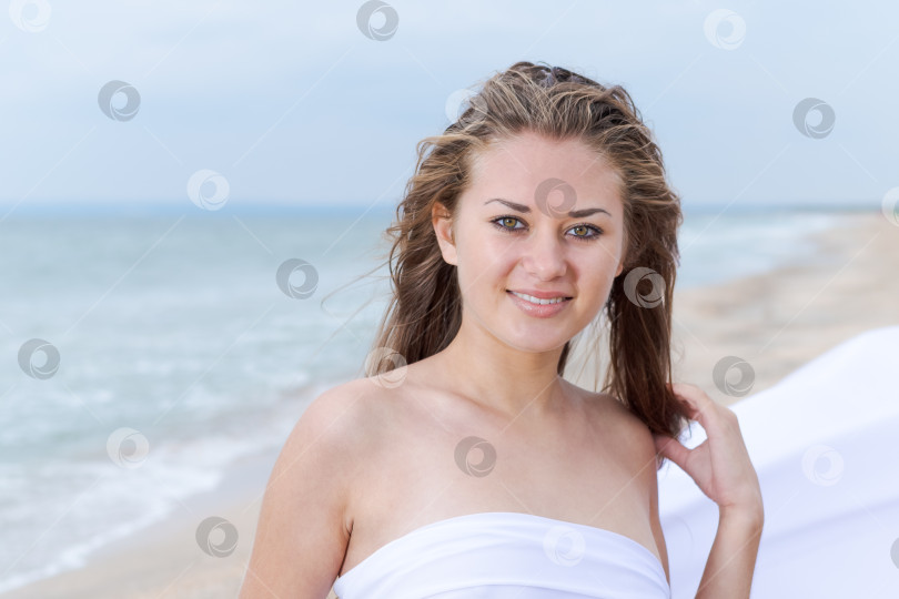 Скачать Женщина с длинными волосами стоит на пляже фотосток Ozero
