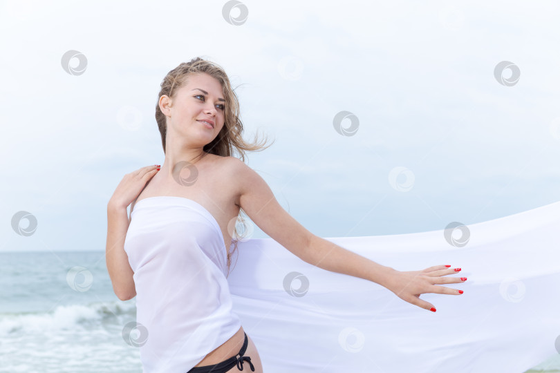 Скачать Женщина стоит на пляже в белом платье фотосток Ozero