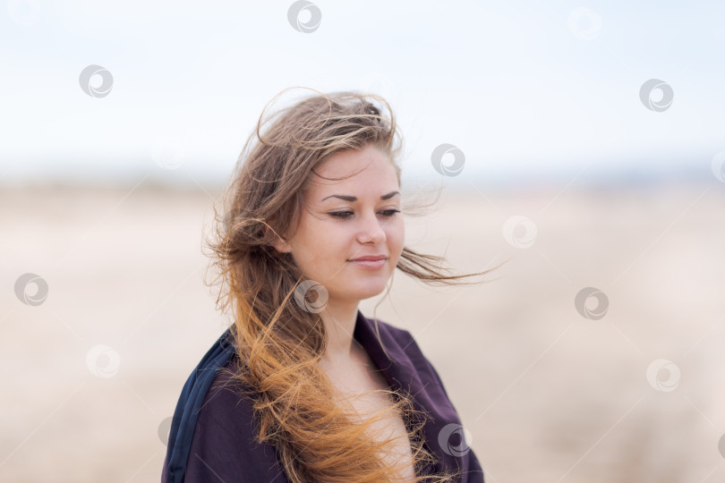 Скачать Женщина с длинными каштановыми волосами стоит на песке фотосток Ozero
