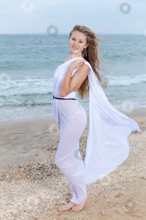 Скачать Женщина в белом платье стоит на пляже фотосток Ozero