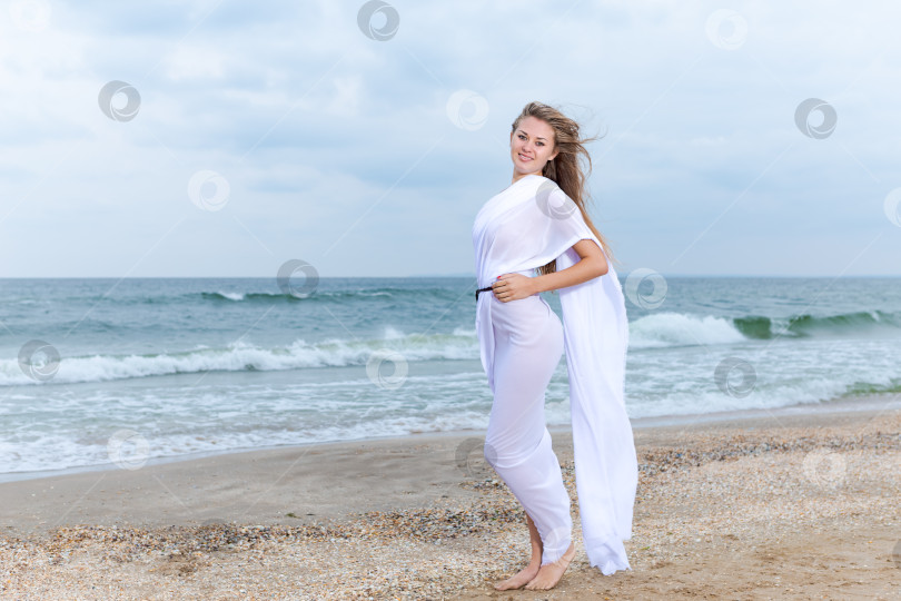 Скачать Женщина стоит на пляже в белом платье фотосток Ozero