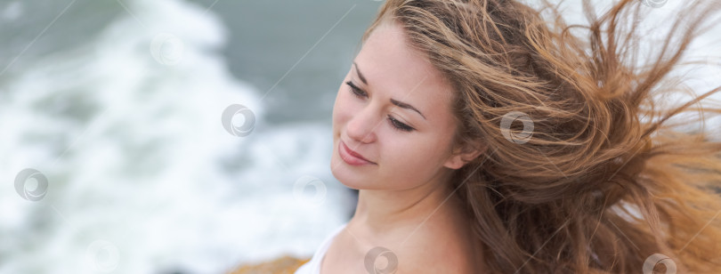 Скачать Женщина с длинными каштановыми волосами стоит на пляже фотосток Ozero