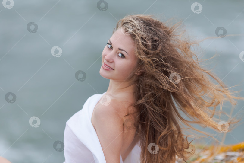 Скачать Женщина с длинными волосами стоит на пляже фотосток Ozero