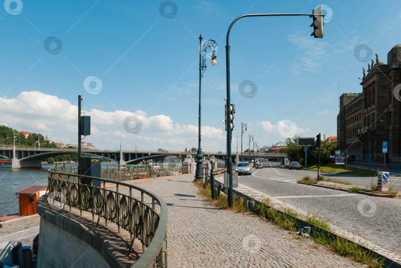 Скачать Живописный городской берег реки с мостом в ясный день фотосток Ozero