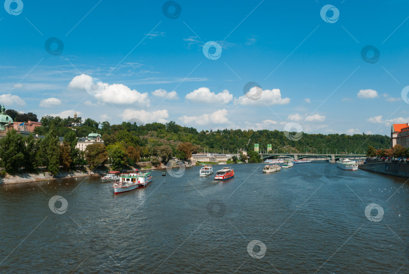 Скачать Живописный вид на реку с лодками и пышной зеленью под ясным голубым небом фотосток Ozero