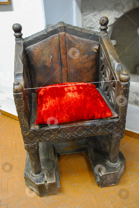 Скачать Исторический деревянный трон с красной бархатной подушкой в средневековой обстановке фотосток Ozero