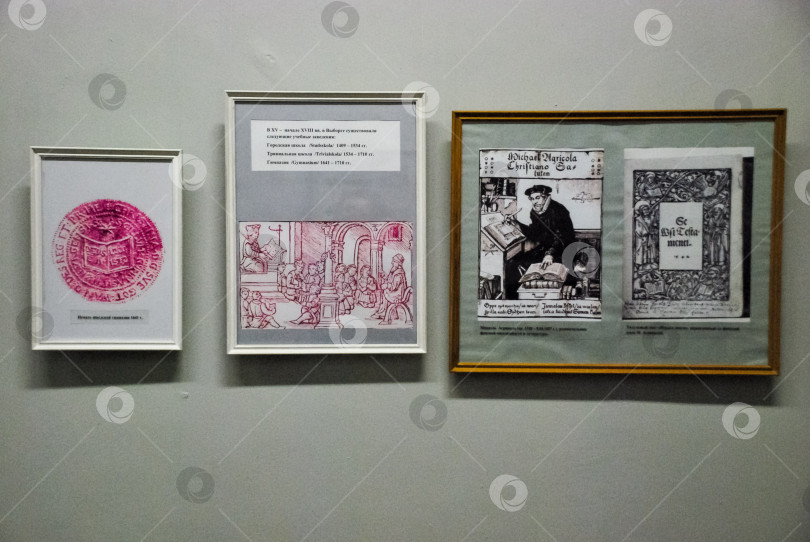 Скачать Экспозиция исторических печатных экспонатов с надписями и иллюстрациями на стене в рамке фотосток Ozero