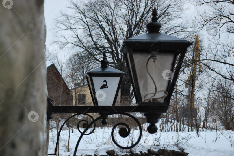 Скачать Старинные уличные фонари с заснеженными деревьями и домами в зимней обстановке фотосток Ozero