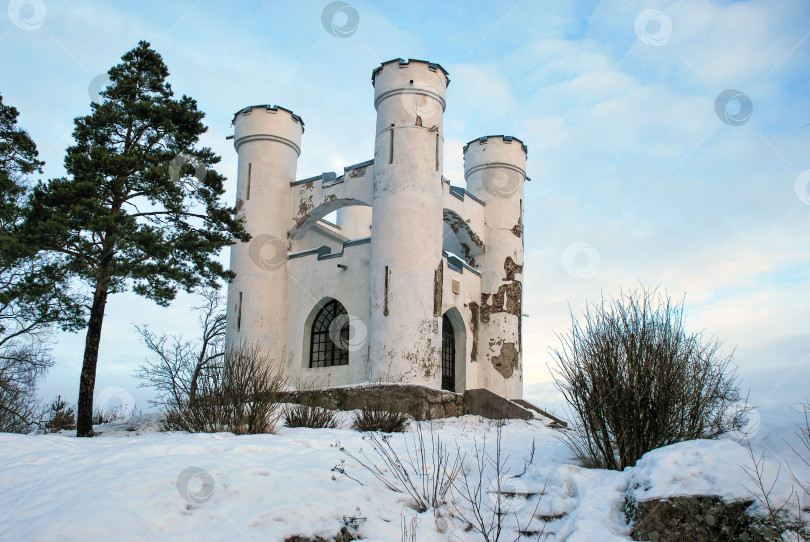 Скачать Заснеженный средневековый замок с башнями, окруженный деревьями зимой фотосток Ozero