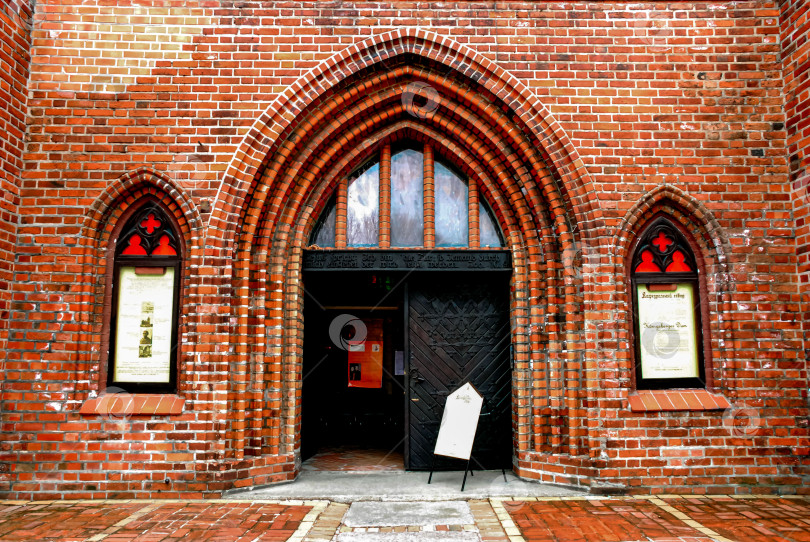 Скачать Готический арочный кирпичный вход в церковь с деревянной дверью и окнами с красной отделкой фотосток Ozero