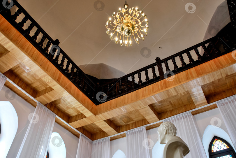 Скачать Элегантная люстра в историческом здании с деревянным потолком и витражами фотосток Ozero