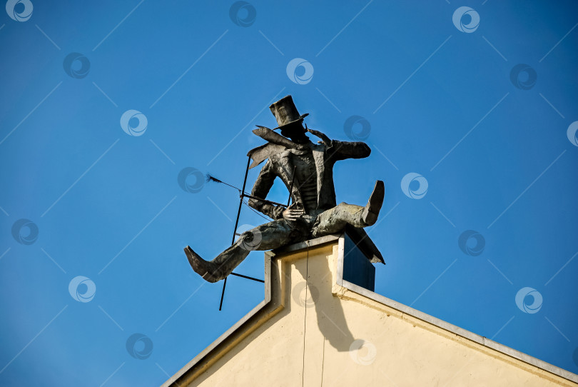 Скачать Силуэт статуи скрипача, балансирующего на крыше на фоне ясного голубого неба фотосток Ozero