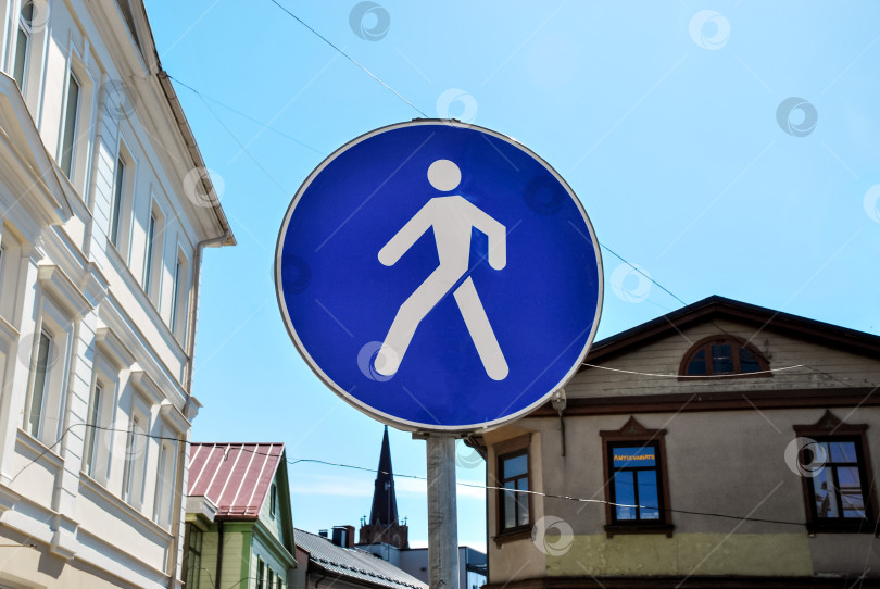 Скачать Синий знак пешеходного перехода на городской улице при ярком дневном свете фотосток Ozero