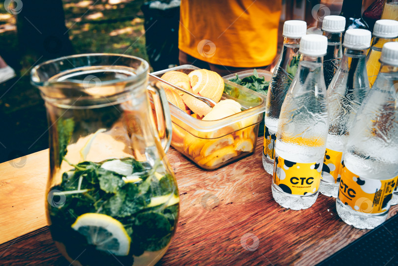 Скачать Москва, Россия, 27 июля 2019 года, бутылка минеральной воды с лимоном на столе фотосток Ozero