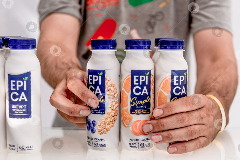 Скачать Москва, Россия, 7 июля 2019 года, работник выставляет бутылку йогурта Epica на прилавке магазина фотосток Ozero