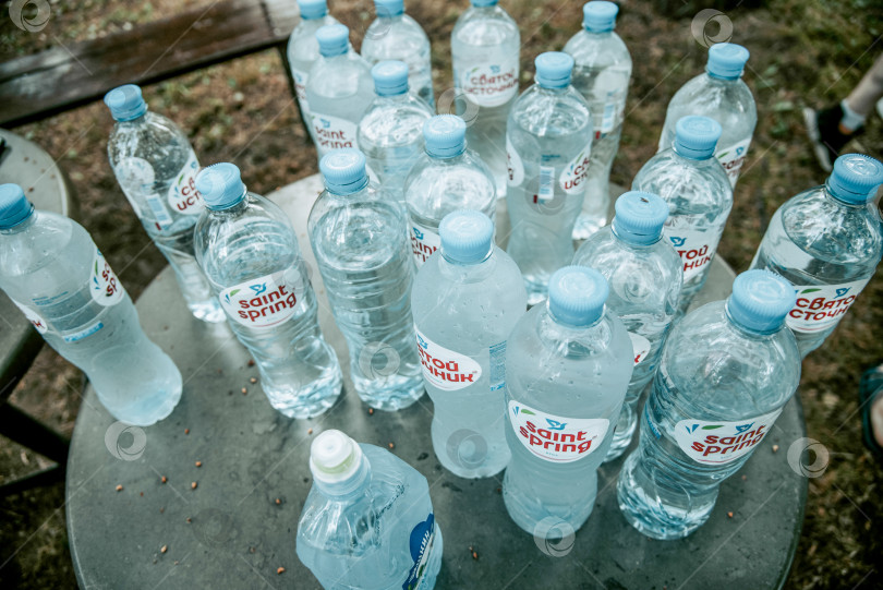 Скачать Москва, Россия, 1 мая 2021 года, Открытые упаковки бутылочной минеральной воды "Святой источник" фотосток Ozero
