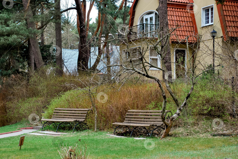 Скачать Очаровательный коттедж со скамейками в тихом саду фотосток Ozero