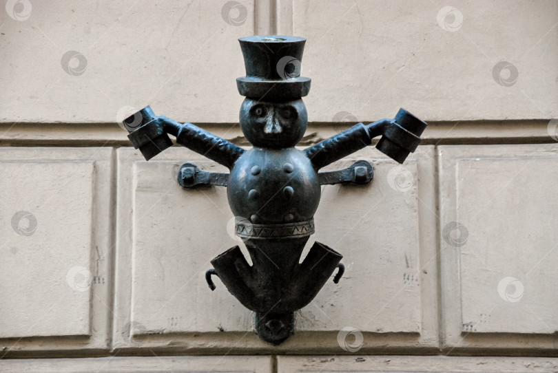 Скачать Декоративная металлическая фигура с цилиндром на текстурированной стене фотосток Ozero