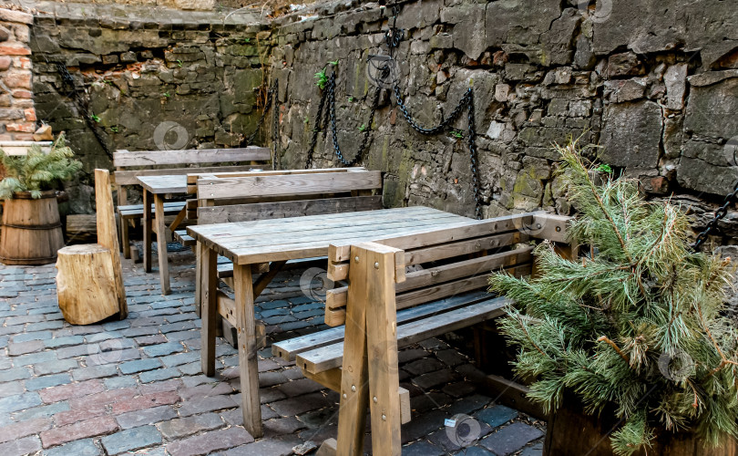 Скачать Кафе на открытом воздухе в деревенском стиле с деревянными столами и кирпичными стенами фотосток Ozero