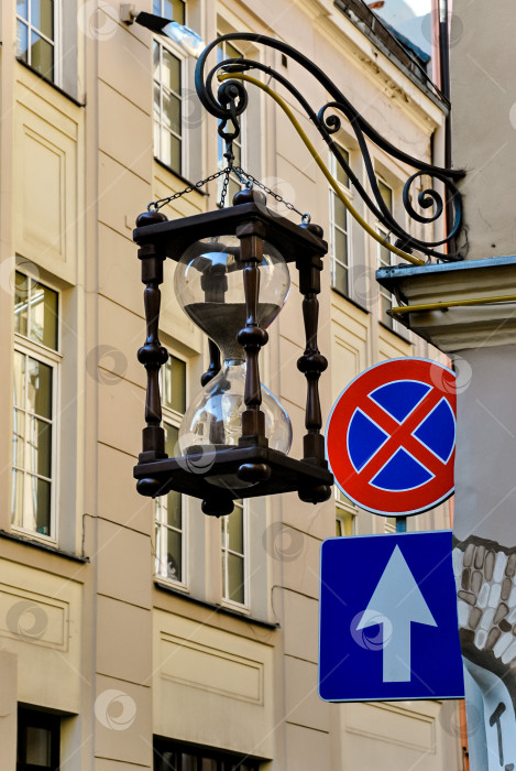 Скачать Старинные деревянные песочные часы и уличные знаки на историческом городском здании фотосток Ozero