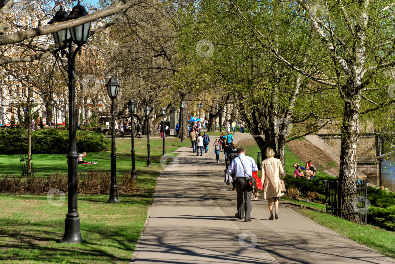 Скачать Весенняя дневная прогулка по городскому парку с деревьями и фонарными столбами фотосток Ozero