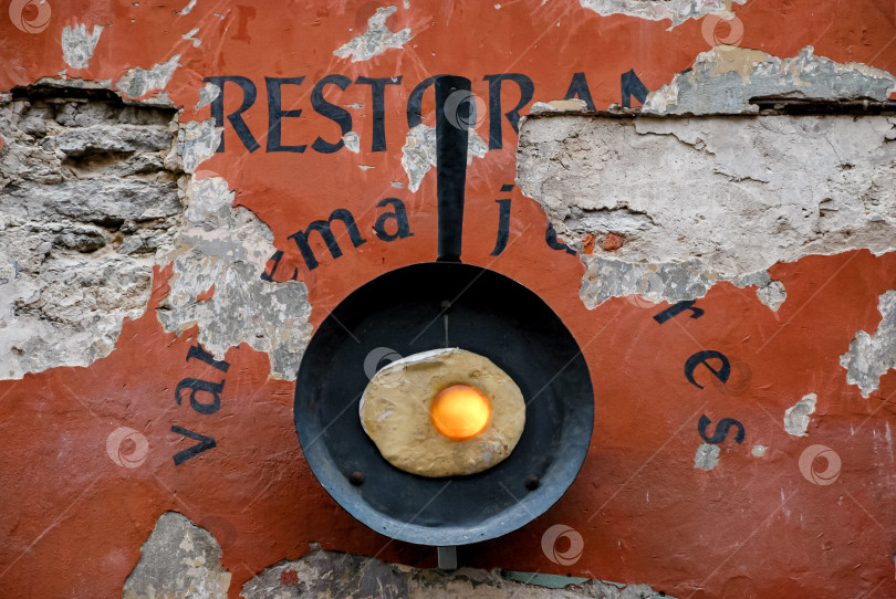 Скачать Художественная сковорода с яйцом солнечной стороной вверх на фоне стены в деревенском стиле фотосток Ozero