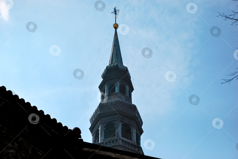 Скачать Старинный шпиль церкви на фоне голубого неба с флюгером фотосток Ozero