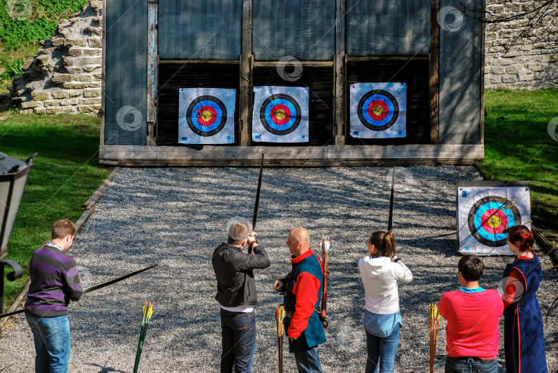Скачать Групповая стрельба из лука с различными участниками практиковать на открытом воздухе в целевом диапазоне фотосток Ozero