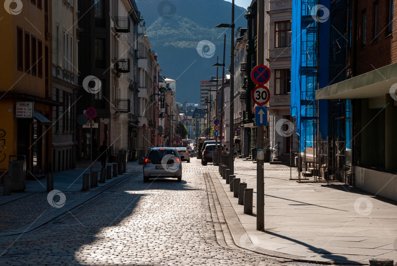 Скачать Солнечная городская улица с автомобилями и красочными зданиями в европейском городе фотосток Ozero