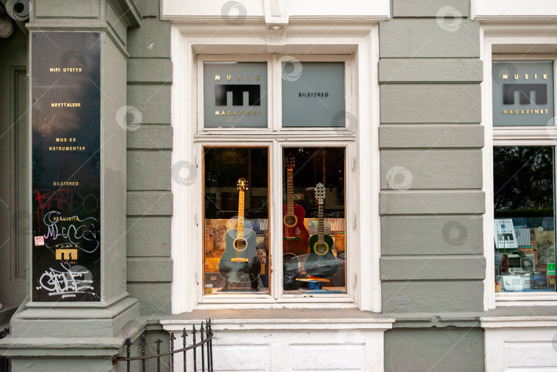 Скачать Витрина винтажного музыкального магазина с гитарами, выставленными в уличной витрине фотосток Ozero