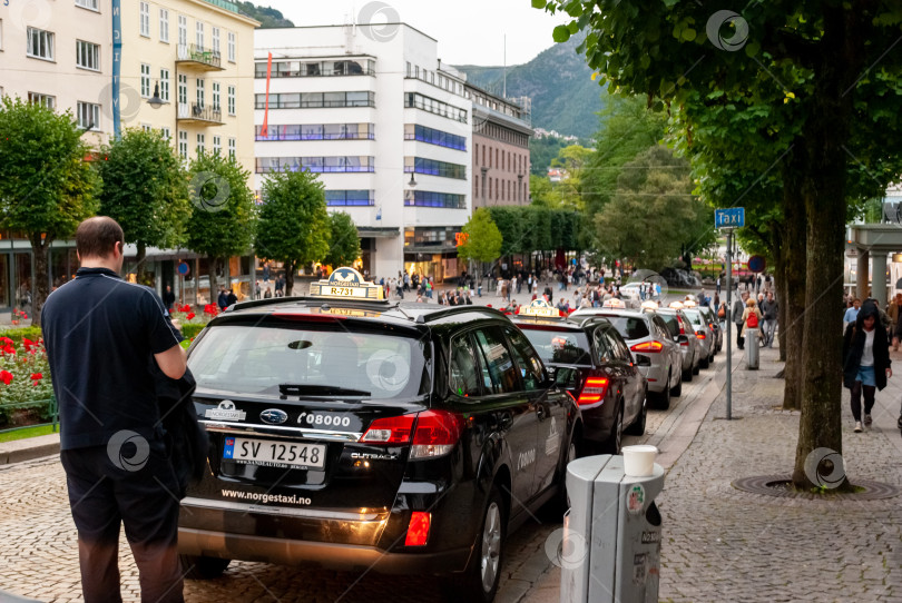 Скачать Оживленная городская улица с такси среди взрослых кавказцев в оживленный день фотосток Ozero