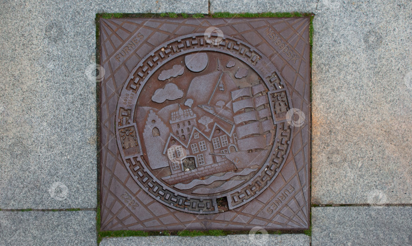 Скачать Богато украшенная круглая крышка люка с изображением парусника и зданий фотосток Ozero