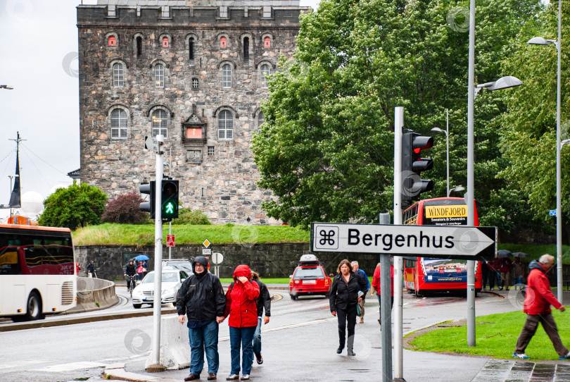 Скачать Дождливый день в Бергене: люди прогуливаются возле исторической крепости фотосток Ozero